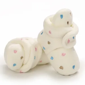 Detail view of soft fuzzy baby winter boots with colorful embroidered heart patterns