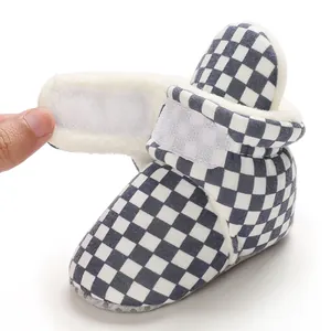 Detail view of plush-lined checkerboard baby bootie with adjustable velcro strap