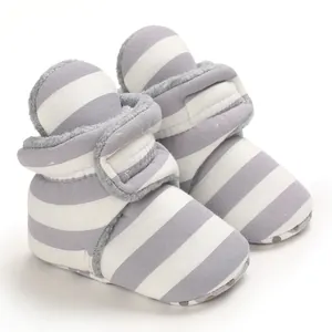 Nahaufnahme grau-weiß gestreifter Babystiefel mit Fleece-Futter und weichen Sohlen.