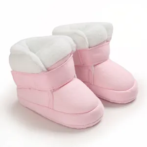 Detail van roze baby winterlaarsjes met zachte witte fleecevoering en klittenband