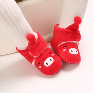 Détail de bottes en peluche rouges pour bébé avec motif cochon et doublure en polaire douce