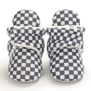 Close-up of checkered baby winter boots with soft fleece lining and velcro strap