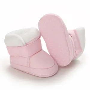 Detail van roze babyboots met zachte zool, witte imitatiebontvoering en antislipbodem.