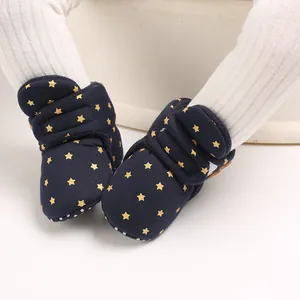Primer plano de botas de nieve para bebé azul marino con estrellas amarillas y forro.