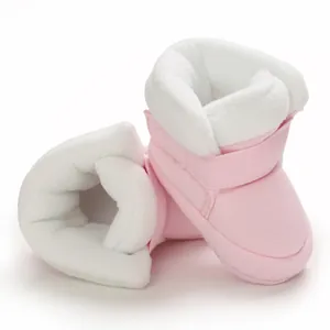Detailweergave van zachte roze baby winterlaarzen met warme witte pluche voering.