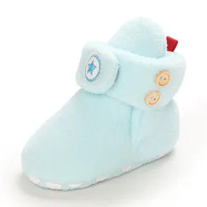Detailweergave van lichtblauwe pluche babylaarzen met sterlogo en houten knopen aan de zijkant