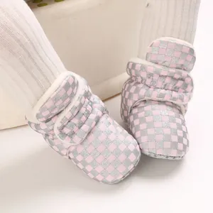 Close-up of pink checkered baby winter boots with warm plush lining and velcro.