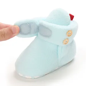 Dettaglio della chiusura a strappo regolabile sugli stivaletti invernali in peluche.