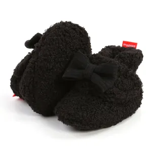 Detailansicht der schwarzen flauschigen Babystiefel mit Schleife und rotem Markenetikett