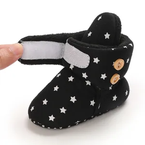 Detalle de botas de nieve para bebé con forro polar, cierre de velcro y estrellas.