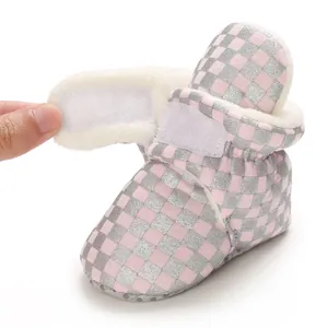 Detail view of pink checkered baby boot with soft fleece lining and velcro strap.