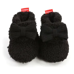 Detailansicht der schwarzen flauschigen Babystiefel mit großer Strickschleife für den Winter