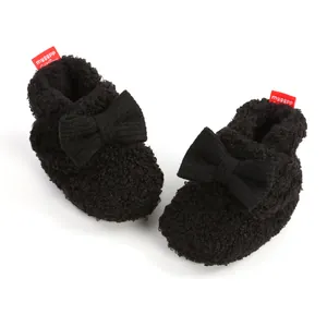 Detailansicht von schwarzen Fleece-Baby-Winterstiefeln mit einer großen dekorativen Schleife