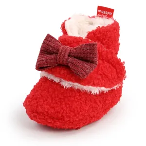 Detailansicht eines roten Baby-Fleece-Stiefels mit einer dunkelroten Strickschleife