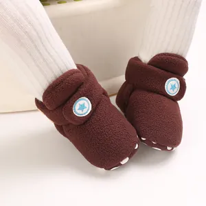 Close-up van bruine pluche winterlaarzen voor baby's met zacht fleece en sterdetail