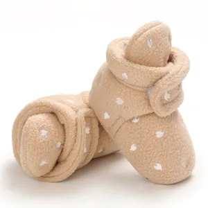 Close-up of warm khaki fleece baby snow boots with white heart print for infants