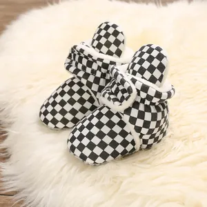 Detailed close-up of black and white checkered baby winter boots with soft plush lining.