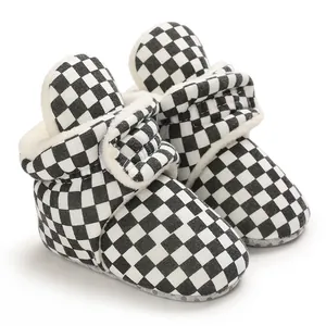 Detailed view of baby winter warm boots with black and white checkerboard pattern.
