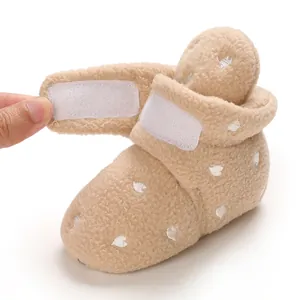 Detail of soft fleece baby bootie showing the adjustable hook and loop closure