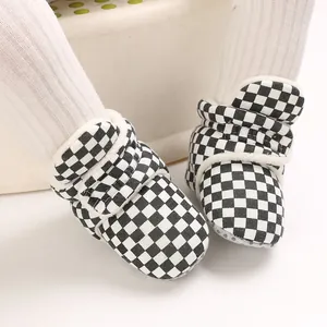 Close-up detail of black and white checkered baby snow boots with soft fleece lining