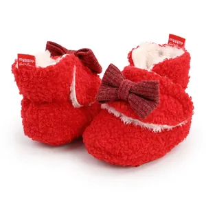 Detailaufnahme roter flauschiger Baby-Winterstiefel mit Schleife und Markenetikett