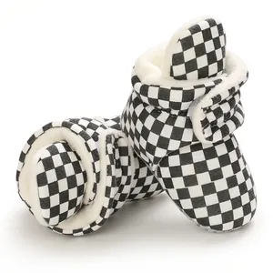 Detailed macro view of black and white checkerboard baby snow boots with warm fleece lining