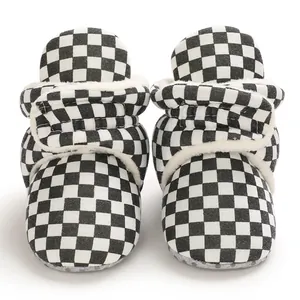 Detail view of checkerboard pattern baby fleece warm winter boots with velcro strap