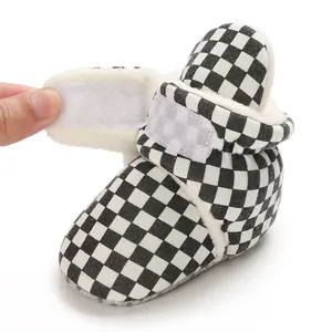 Detail of checkerboard baby bootie with warm fleece lining and Velcro closure