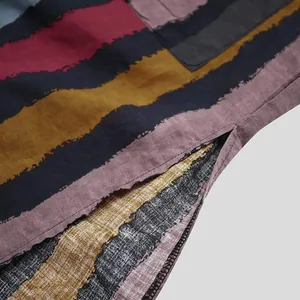 Close-up of retro striped long robe fabric showing detailed texture and side slit.