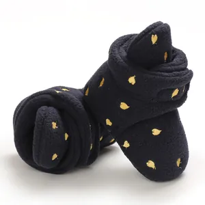 Close-up of navy blue baby fleece booties with golden heart patterns for winter