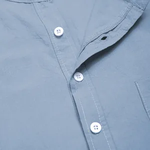 Close-up of white buttons and stitching on light blue men's long-sleeved robe