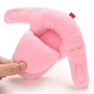 Dettaglio di stivaletti invernali in peluche rosa per neonati con chiusura a strappo
