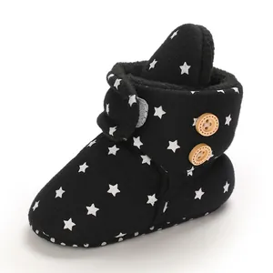Detalle de botas de bebé negras con patrones de estrellas blancas y forro polar muy cálido
