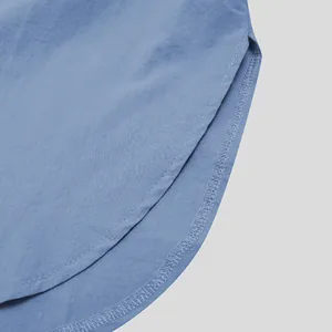 Macro detail of men's blue robe hem showing clean stitching and light fabric texture