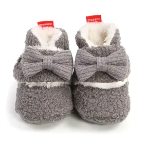 Detailansicht grauer flauschiger Babystiefel mit dekorativer Strickschleife und warmem Fleecefutter