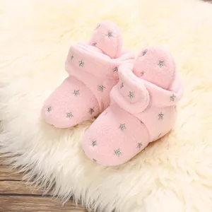 Detail shot of pink baby star-patterned fleece booties with velcro strap on soft fur