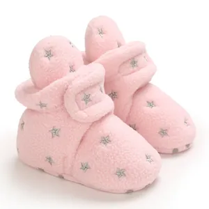 Close-up of pink fleece baby snow boots featuring silver star patterns and velcro closure