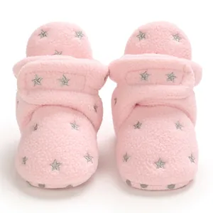 Detailed view of soft pink fleece baby winter boots featuring silver star pattern embroidery