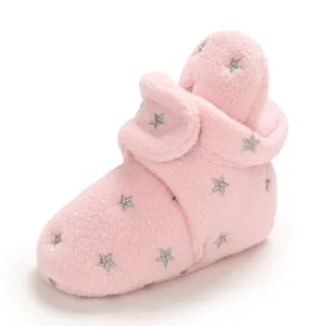 Dettaglio di scarponcini neonato in pile rosa con stelle argento e chiusura velcro