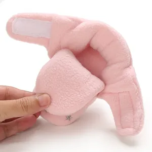 Close-up detail of a soft pink plush baby snow bootie with Velcro strap for warm winter wear