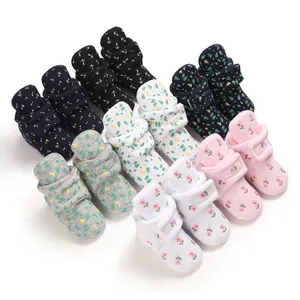 Auswahl an gemütlichen Baby-Booties mit Blumen- und Blattprint für den Winter.