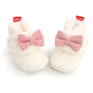 Weiche flauschige weiße Baby-Winterstiefel mit rosa Schleifen-Detail Makroansicht