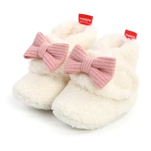 Detailansicht von flauschigen weißen Babystiefeln mit weichen rosa Strickschleifen