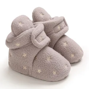 Detailed view of grey fuzzy baby snow boots with gold embroidered stars and strap