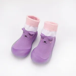 Close-up of purple baby knit walker shoes with cute cartoon cat face and soft rubber sole.