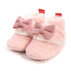 Detailaufnahme warmer rosa Plüsch-Babyschuhe mit Schleife für den Winterkomfort