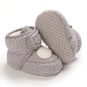 Dettaglio scarponcini neonato in peluche grigio con suola morbida antiscivolo