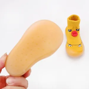 Detail showing the soft anti-slip rubber sole of yellow cartoon duck baby walking shoes