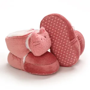 Detalle de patucos rosas para bebé en pana con gato lindo y suela antideslizante.