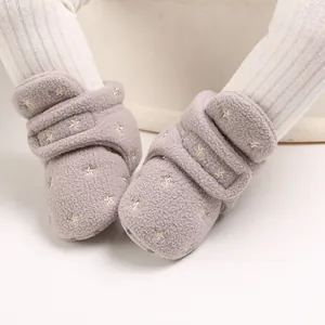 Close-up of warm baby fleece boots with gold star embroidery and Velcro strap
